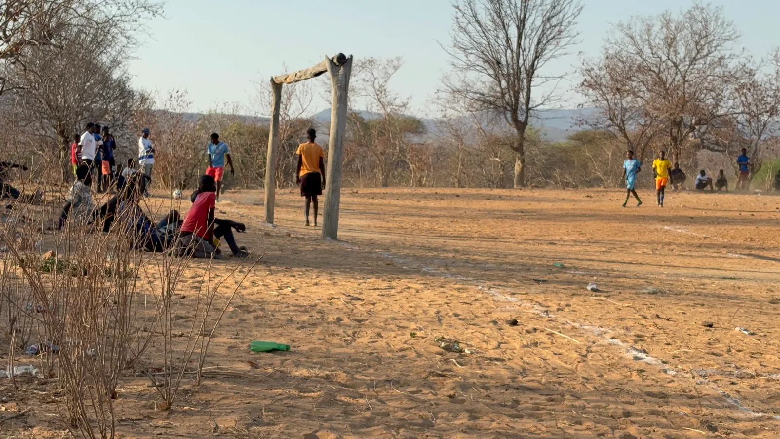 Players and spectators on the open field in Munyama during the tournament