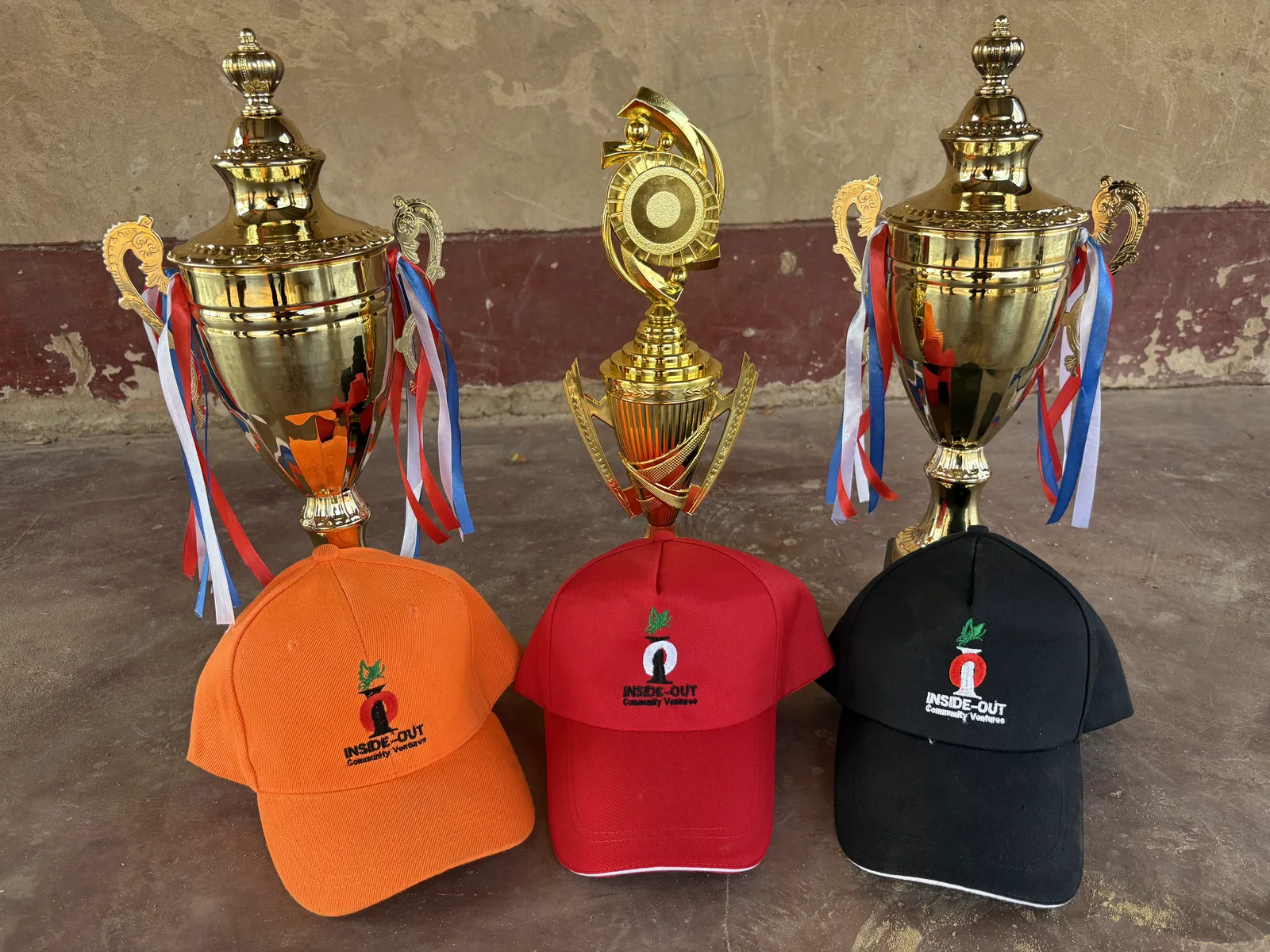 Three tournament trophies and Inside-Out Community Ventures caps awaiting presentation